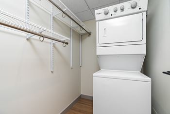 A white oven and dryer in a small laundry room.at Raymond Block, Edmonton